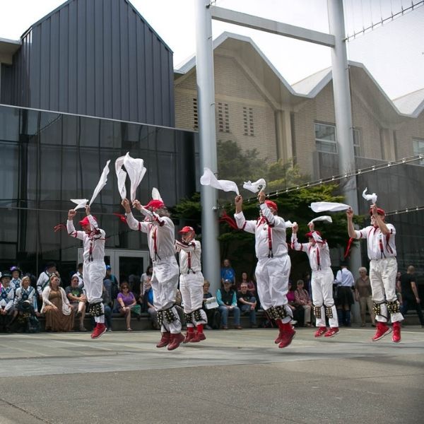 A group of dancers jumping in the air with scarves
