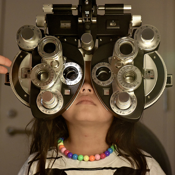 image of a young girl behind an optical machine