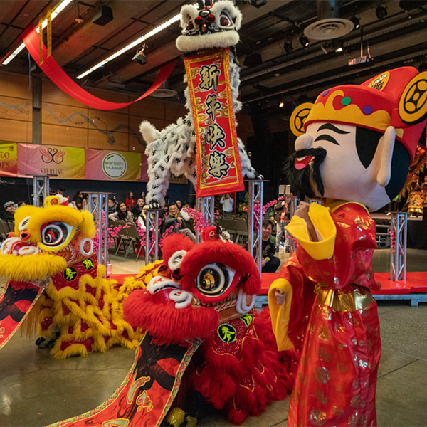 Event hall filled with traditional Vietnamese costumes of dragons and a man.