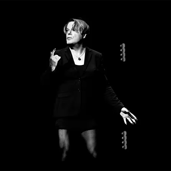 Women posing in a black suit.